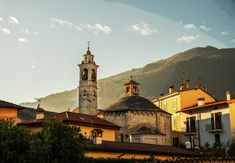 an old church tower towering over the city below it's surrounding hills and mountains