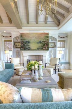 a living room filled with furniture and a flat screen tv mounted to the wall over a fire place