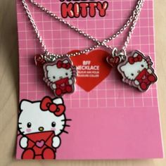 two hello kitty necklaces on a pink card