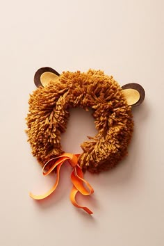 a brown teddy bear hat with an orange ribbon around it