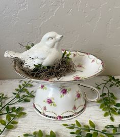 a white bird sitting on top of a cake plate