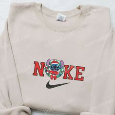 Introducing the exclusive Nike x Santa Stitch Christmas Wreath Embroidered Sweatshirt, a true holiday marvel! This sweatshirt combines the iconic Nike design with the festive charm of Santa Stitch embroidery, creating a unique and eye-catching piece. Made with premium quality materials, this sweatshirt offers unrivaled comfort and durability. It features a cozy fleece lining, ensuring warmth during chilly winter days. Perfect for gifting, this sweatshirt is a fantastic Christmas present idea for Nike Cartoon, Nike Inspired, Embroidered Apparel, Best Family Gifts, Mike Wazowski, Shirt Nike, Daisy Duck, Hoodie Material, Custom Nikes