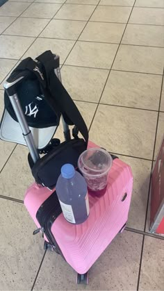 a pink piece of luggage sitting on top of a tiled floor