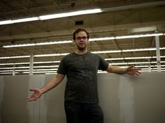 a man leaning against a wall with his hands out