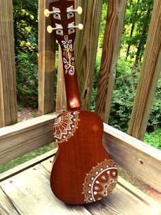 a wooden guitar sitting on top of a wooden deck