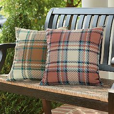 two pillows sitting on top of a wooden bench