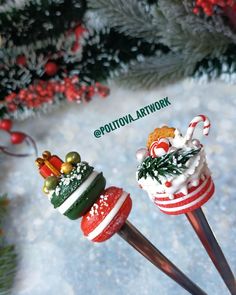 two christmas themed candy lollipops sitting on top of each other in the snow