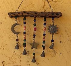 a wind chime hanging on the side of a building with bells and stars attached to it