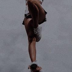 a woman is upside down in the water while holding onto her leg and jumping into the air