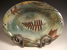 a ceramic plate with a leaf design on it