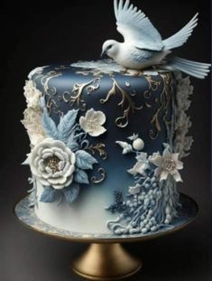 a blue cake with white flowers and a bird on top