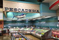 the inside of a deli filled with lots of fresh produce and fish on display