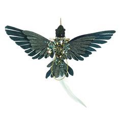 a green bird ornament with feathers and beads on it's back end