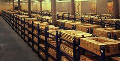 rows of shelves filled with wooden boxes in a warehouse