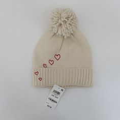 a white hat with red hearts on it and a price tag attached to the cap