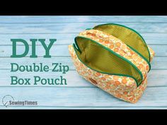 the diy double zip box pouch is sitting on top of a blue wooden table