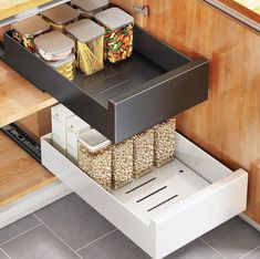 an open drawer in the middle of a kitchen with food items and containers on it