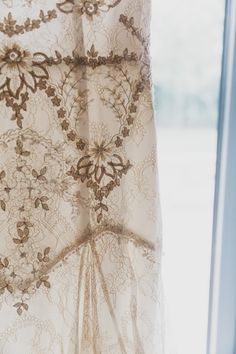 the curtain is hanging in front of a window with an intricate lace design on it