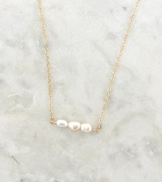 This pearl bar necklace is a beautiful staple piece! Gorgeous freshwater pearls on a dainty 14k gold filled or sterling silver chain. A timeless and chic piece perfect for your everyday and special looks. Please understand that every pearl is unique, and may slightly vary in size, and shape. This allows your pearl jewelry to be handcrafted and special, just for you. Details: Pearl measures 5 - 6 mm Nickel free and hypoallergenic Will not tarnish All of our jewelry is handmade with love in Nova S Dainty Birthstone Pearl Necklace Gift, Minimalist 14k Gold-filled Pearl Necklace For Everyday, Everyday 14k Gold-filled Pearl Necklace With Delicate Chain, 14k Gold-filled Pearl Necklace As A Gift, Dainty Gold-toned Sterling Silver Bar Necklace, Pearl Bar Necklace, Pure Gold Jewellery, June Birthstone, Wedding Jewellery Necklace