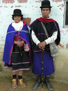 two people standing next to each other in front of a building