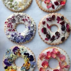 a bunch of doughnuts that have been decorated with flowers and icing on them