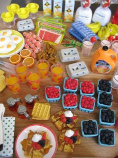 a wooden table topped with waffles, fruit and other foods on top of it