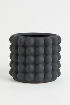 a black vase sitting on top of a white table