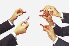 four people in suits are holding pens and pointing them at the same person's fingers