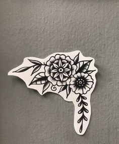 a sticker with flowers and leaves on the side of a gray wall in front of a