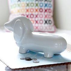 a white dachshund figurine sitting on top of a piece of paper