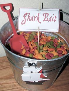 a metal bucket filled with lots of different types of food and a sign that says shark bait