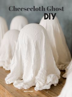 several white cloth covered heads sitting on top of a wooden table next to each other