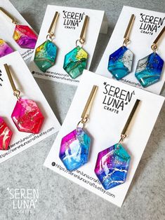 These irregular hexagonal dangle earrings showcase alcohol ink art, personally hand-drawn by me. They feature a vibrant mix of colours, accented with golden ink and a touch of glitter for a dazzling effect. The hexagonal pendants are paired with stainless steel rectangular bars, creating a striking contrast with their simple, clean lines. As wearable art and completely handmade, each piece is truly unique. Earrings are backed with in gold plated 304 stainless steel and butterfly back. Handmade i Colorful Drop Earrings As A Gift, Trendy Hand Painted Jewelry Gift, Colorful Artsy Earrings For Gift, Alcohol Ink Earrings, Alcohol Ink Jewelry, Alcohol Ink Art, Jewellery Handmade, Jewelry Card, Ink Art