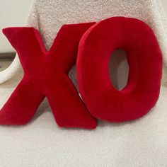 the word xo spelled out in red letters on a white surface next to a stuffed animal