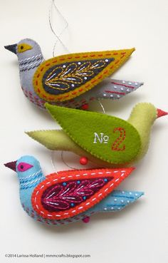 three colorful birds are hanging on the wall