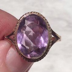 Stunning Vintage 9ct gold sparkly amethyst ring.Here we have a lovely large amethyst ring set in 9ct gold.The faceted amethyst a fabulous rich light purple and dark purple in certain lights with the many faceted amethyst stone. The sparkly amethyst is simply set in a fine gold setting and has a fine gold rope border, with simple openwork gold shoulders, which complement the ring.The ring is in a good Vintage condition.  The Almandine garnet is firmly set in a gold roll over setting, and has no c Gold Faceted Amethyst Ring, Faceted Yellow Gold Amethyst Ring, Faceted Amethyst Ring In Yellow Gold, Gold Amethyst Ring With Diamond Cut, Oval Shape, Gold Oval Amethyst Ring With Diamond Cut, Faceted Gold Amethyst Ring For Anniversary, Classic Yellow Gold Amethyst Ring With Diamond Cut, Oval Amethyst Ring With Diamond Cut, Purple Faceted Ring For Formal Occasions