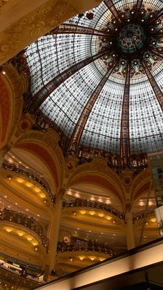 the inside of a large building with a glass dome ceiling and chandelier above it