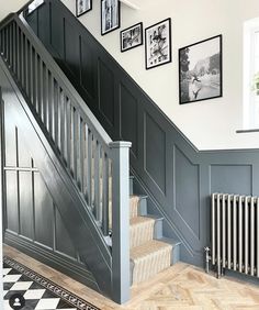 a staircase with pictures on the wall next to it and a radiator below