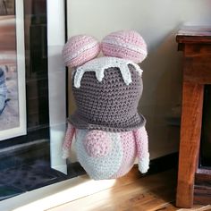 a crocheted stuffed animal is sitting on a shelf next to a framed photograph