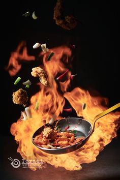 a bowl full of food on fire with chopsticks sticking out of the side