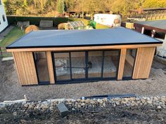 a small wooden building sitting on top of a gravel field