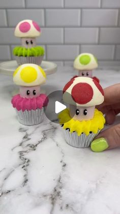 a person holding a knife in front of some cupcakes