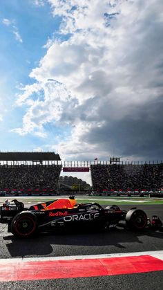 the red bull racing car is driving down the track in front of an empty crowd