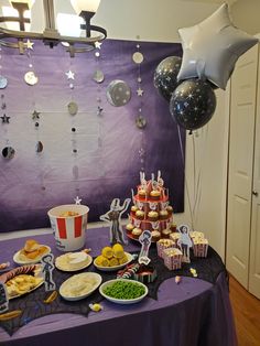 a table topped with lots of food and balloons