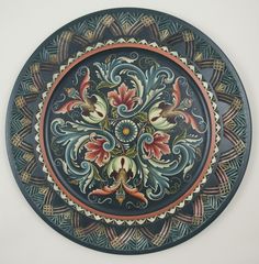 an ornately decorated plate on a white wall