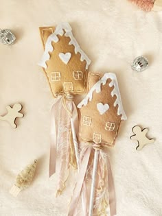 two gingerbread house shaped lollipops on a white blanket