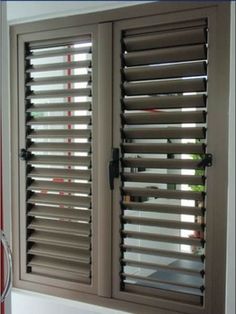 a bathroom window with shutters on the outside