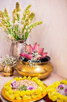 there are some flowers in the vases on the table next to plates with food