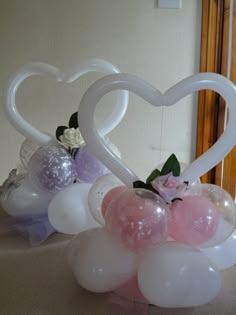 balloons in the shape of hearts and flowers are arranged on a table with other decorations