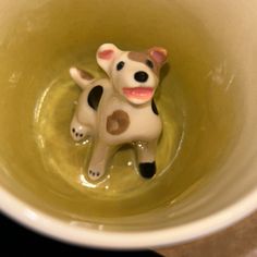 a small toy cow sitting inside of a bowl